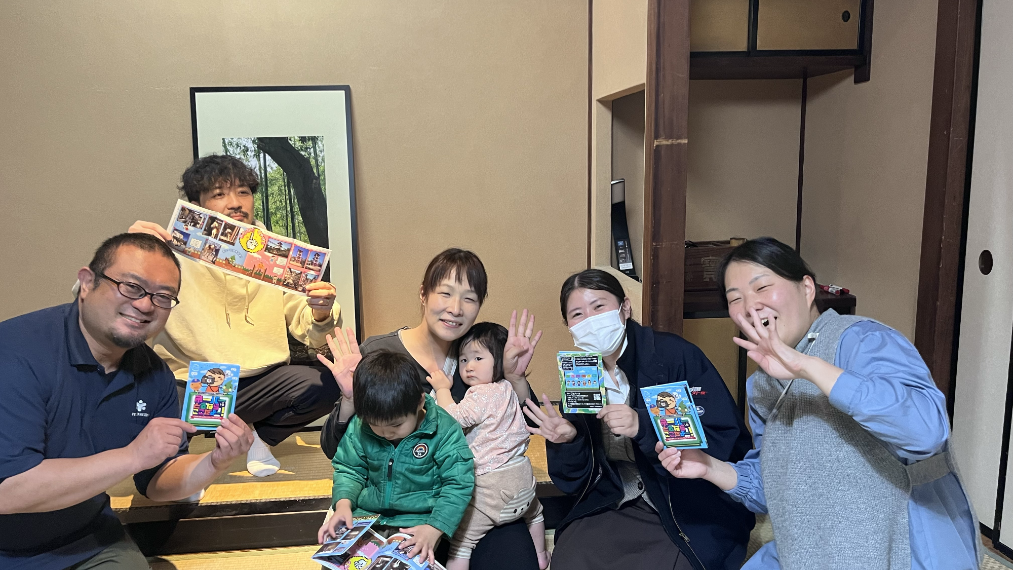 こがキラメンバーが完成したパンフレットを手に持っている様子