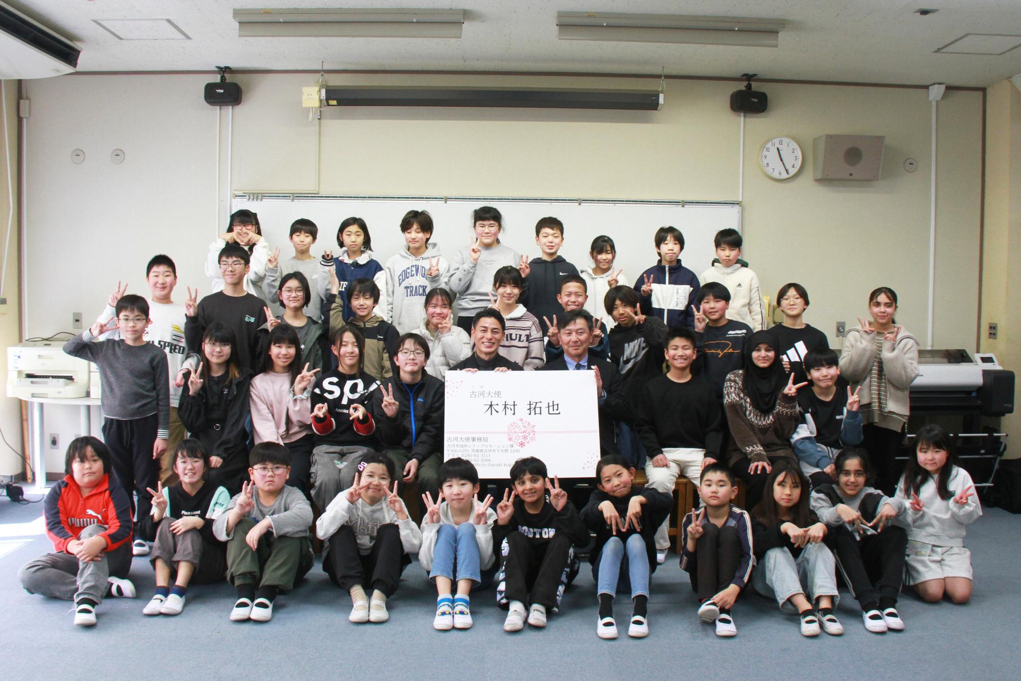 木村拓也さん、針谷市長、それを囲む大和田小学校の生徒と記念撮影