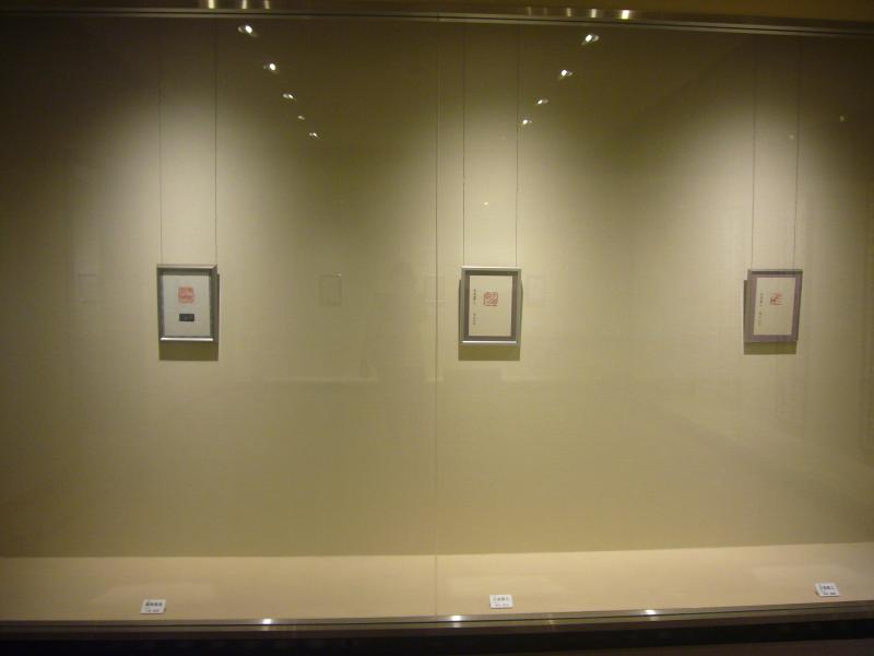 展示ケースの中、額に入った篆刻の作品3点の写真